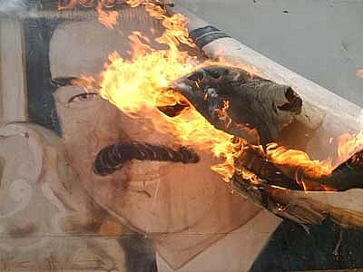 ritratto di Saddam incendiato dagli iracheni stessi