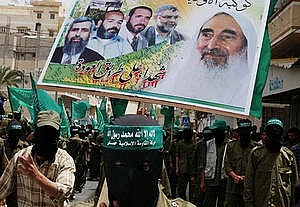 palestinesi mascherati sostengono un poster di Yassin