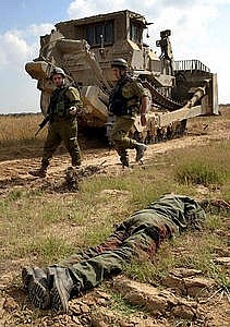 militari israeliani ispezionano il corpo di un palestinese ucciso
