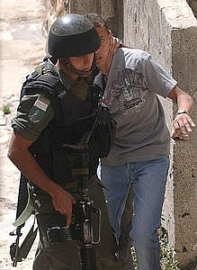 soldato israeliano arresta un giovane palestinese